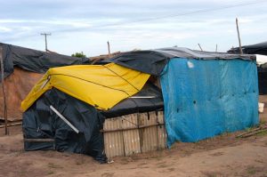 A tent in the Movimento dos Trabalhadores Rurais Sem Terra (MST) encampment made of black, yellow, and blue tarps