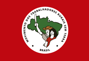 White circle centered on a red background. Inside the circle, an illustration of two people against an outline of Brazil. It reads “Movimento Dos Trabalhadores Rurais Sem Terra, Brazil.”
